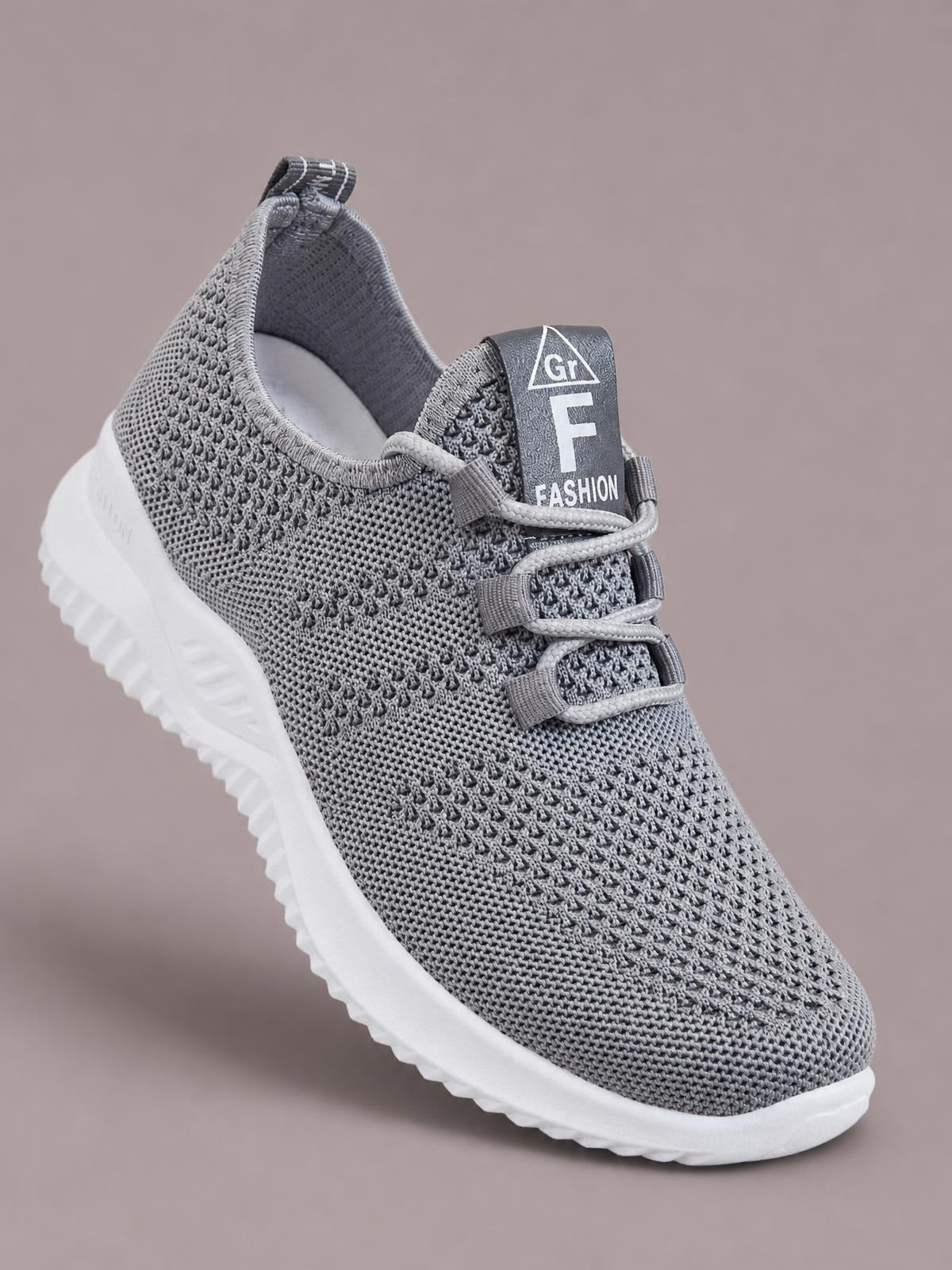 Gray breathable mesh athletic shoe with lace-up closure, a streamlined low-top silhouette, padded collar, and white rubber sole with textured tread.