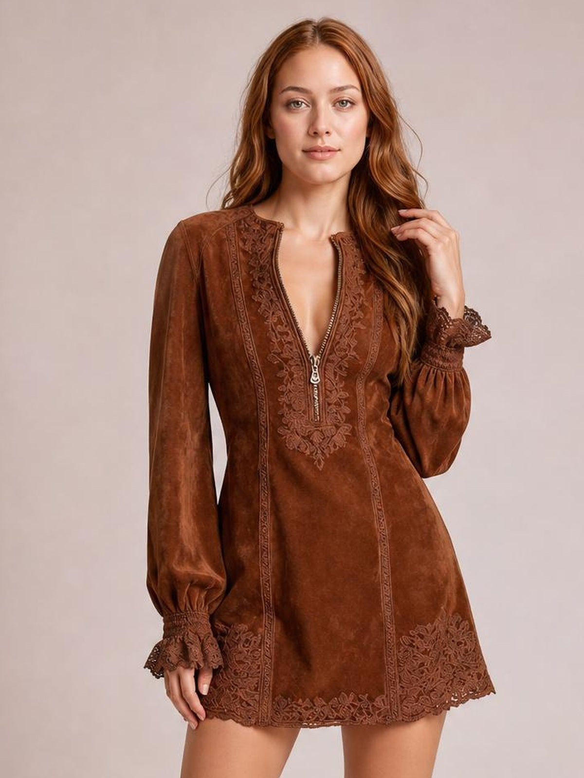 Model poses in a brown long-sleeve mini dress with a front zipper, floral lace detailing, puffed cuffs, and a gently flared silhouette.