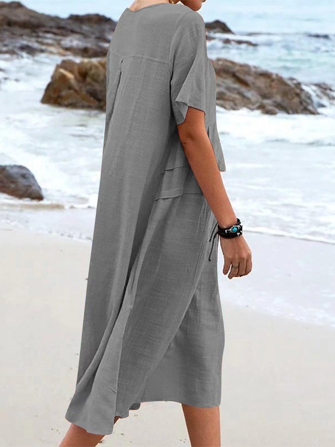 Plus size loose midi dress with short sleeves and pockets shown in cream and black by the beach