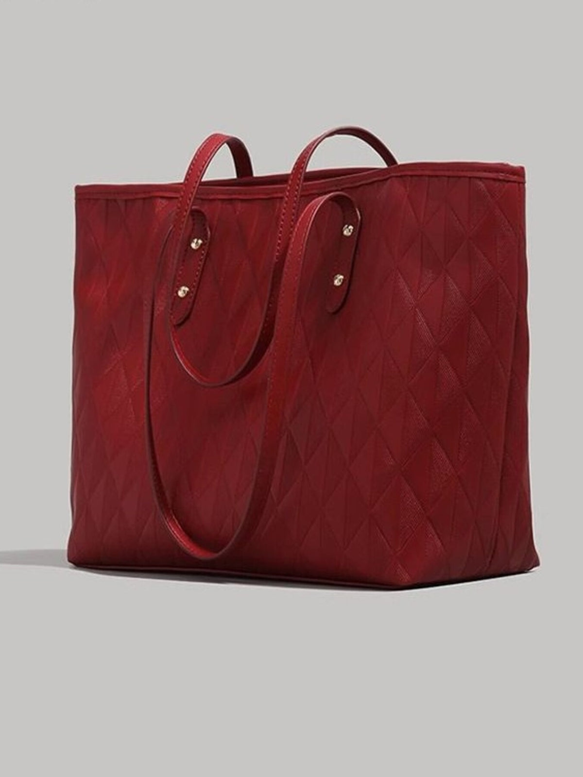 Large burgundy textured PU leather tote bag with diamond quilting, double top handles, reinforced tabs, and a structured open-top silhouette.