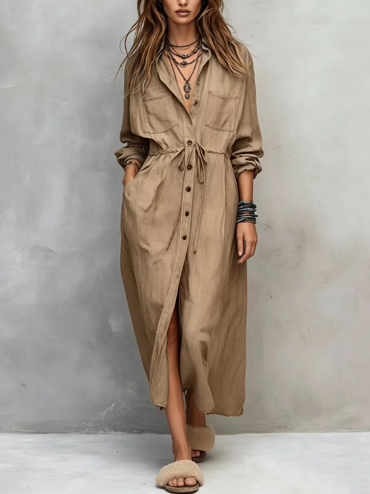 Plus size blue button-front shirt dress with long sleeves, drawstring waist, pockets, and side slit