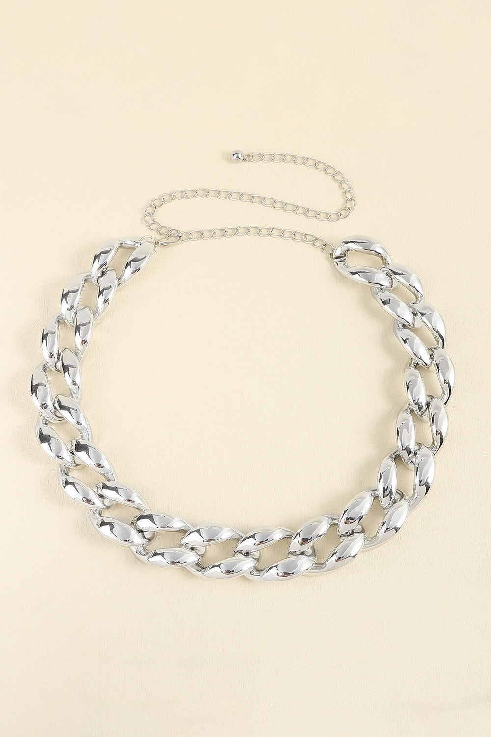 Silver-tone acrylic curb chain belt featuring chunky interlocking links, a 1.2-inch width, and a slender draped chain extension with adjustable fastening.