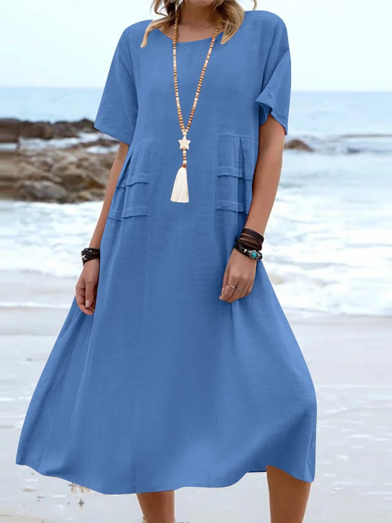 Plus size loose midi dress with short sleeves and pockets shown in cream and black by the beach
