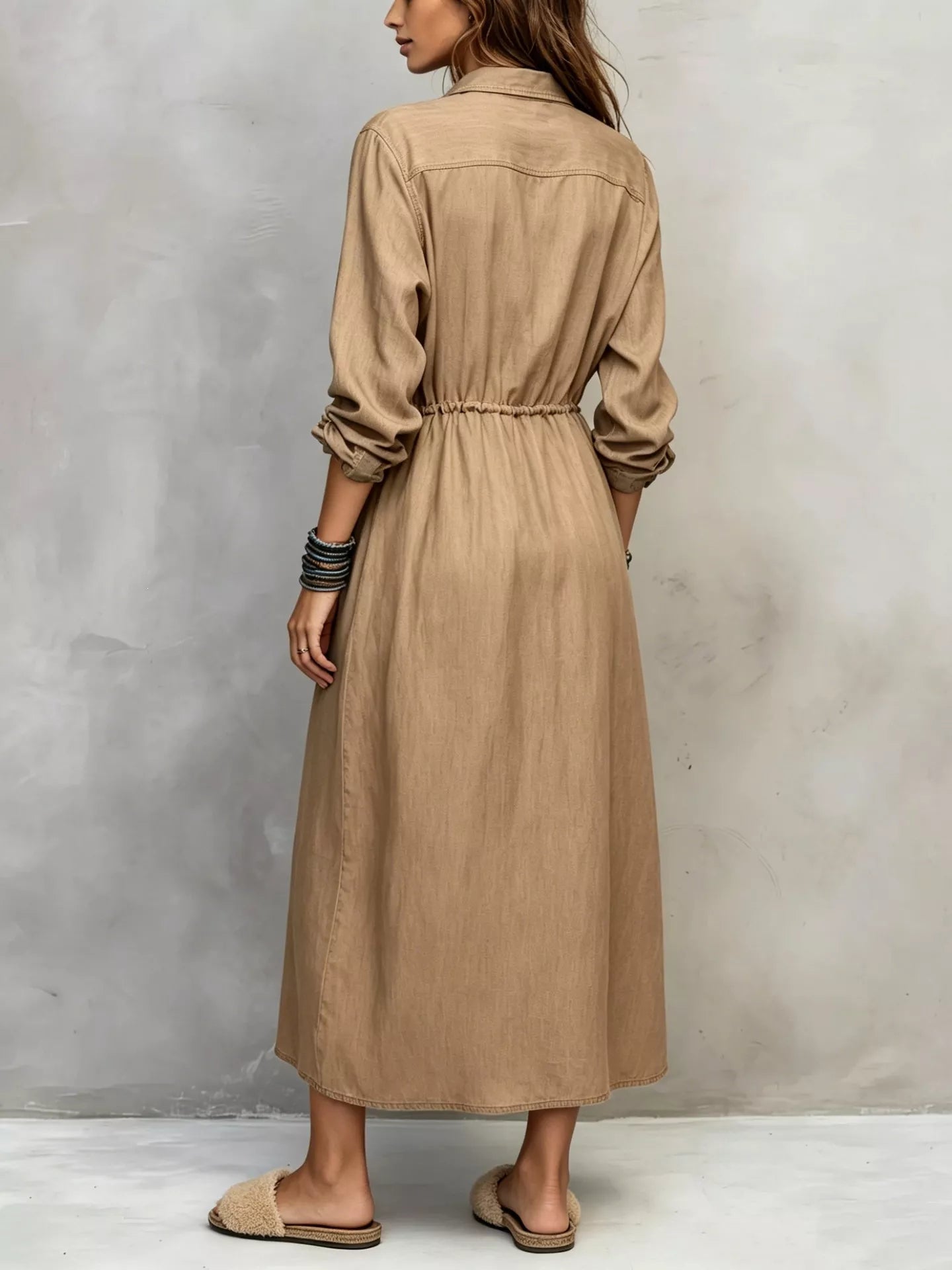 Plus size blue button-front shirt dress with long sleeves, drawstring waist, pockets, and side slit