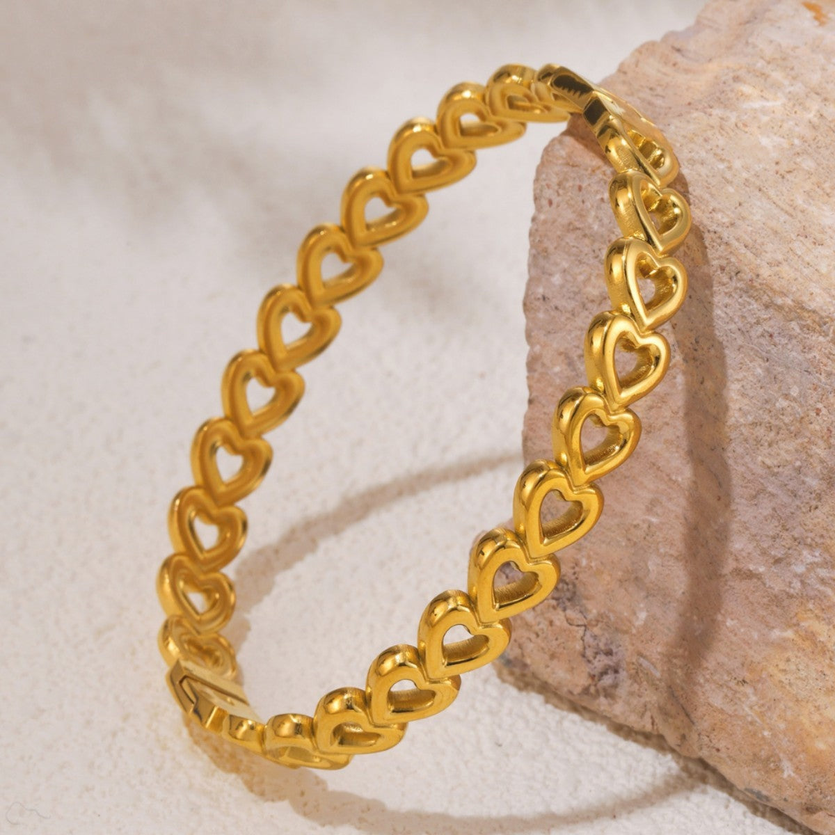 18K gold-plated stainless steel heart bracelet featuring a polished chain of interlocking open-heart links in a rounded silhouette.