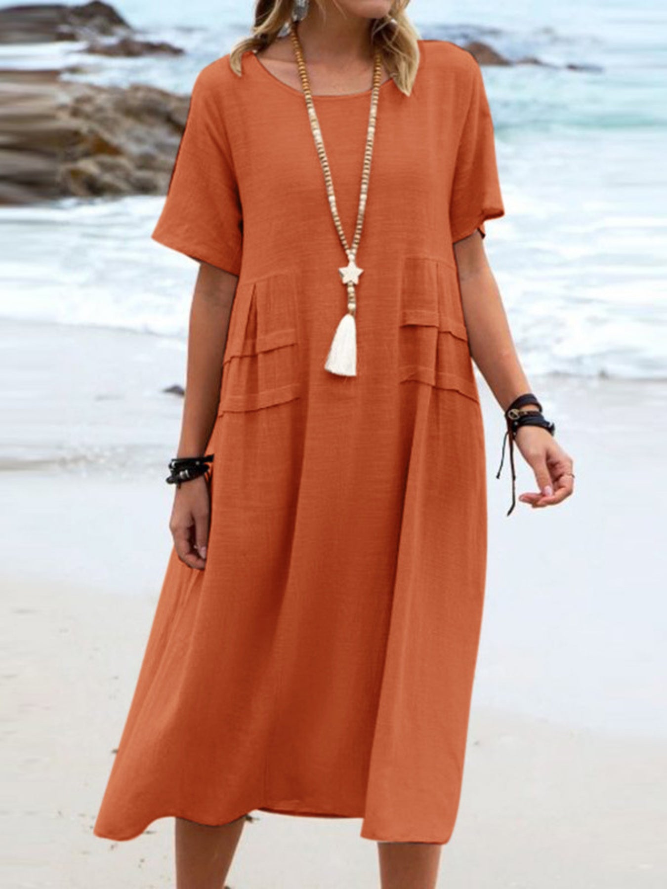 Plus size loose midi dress with short sleeves and pockets shown in cream and black by the beach