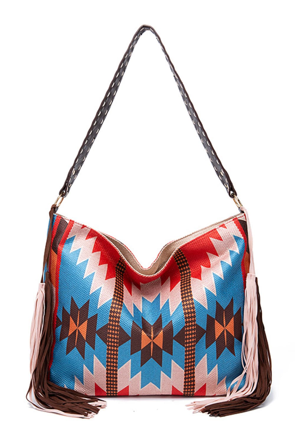 Oversize geometric canvas tote bag with a slouchy silhouette, colorful zigzag pattern, long braided shoulder strap, and multicolor fringe trim.