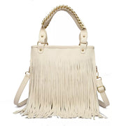Cream medium PU leather handbag with long fringe across the front, structured tote silhouette, dual top handles with chain accents, and an adjustable shoulder strap.