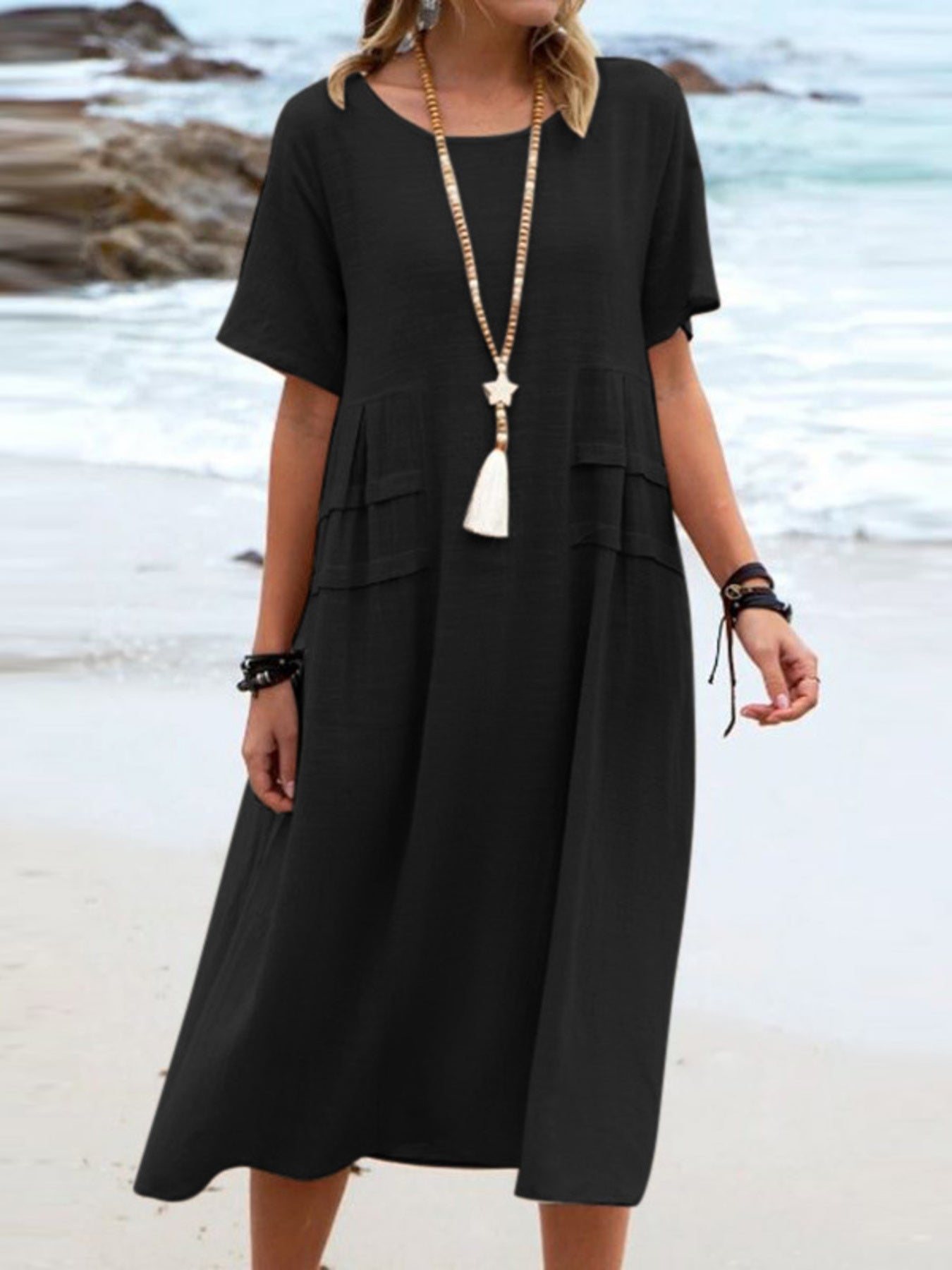 Plus size loose midi dress with short sleeves and pockets shown in cream and black by the beach