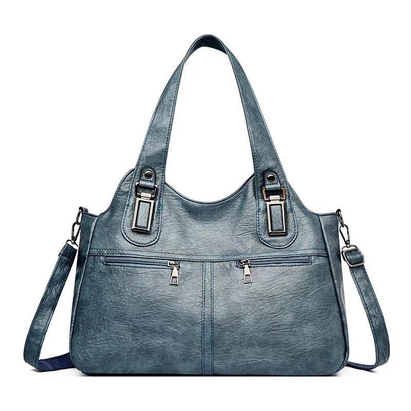 Vintage-style large blue-gray PU leather handbag with twin shoulder straps, front zip pockets, metal accents, and a detachable crossbody strap.