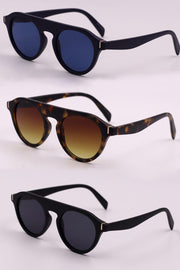 Three pairs of round full-rim polycarbonate sunglasses feature black and tortoiseshell frames with dark or warm gradient lenses and curved temples.