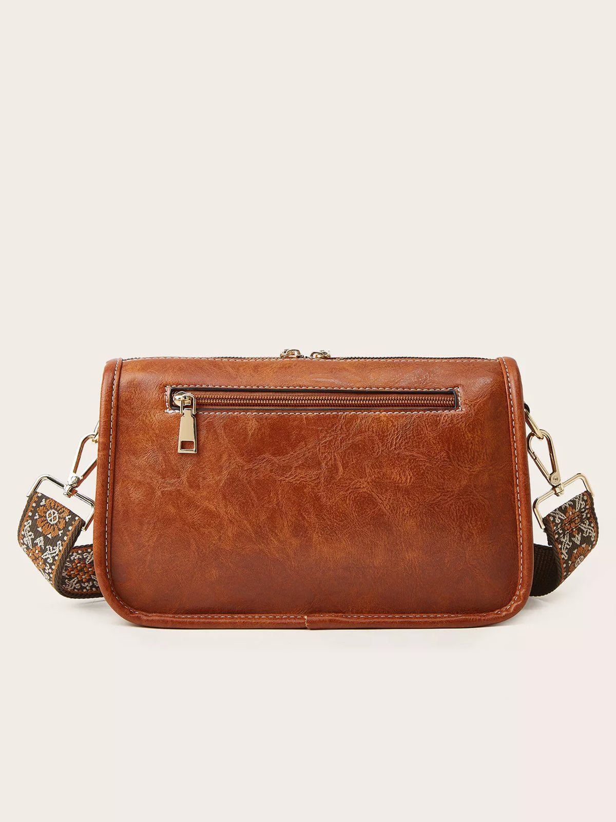 A small vintage-style brown PU leather crossbody bag features a patterned strap, stitched edges, gold-tone hardware, and a front zip pocket.