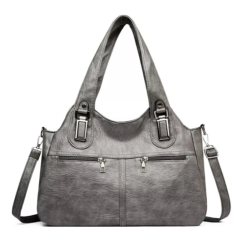 Large vintage-style gray PU leather handbag with dual shoulder handles, front zip pockets, buckle accents, and an adjustable crossbody strap.