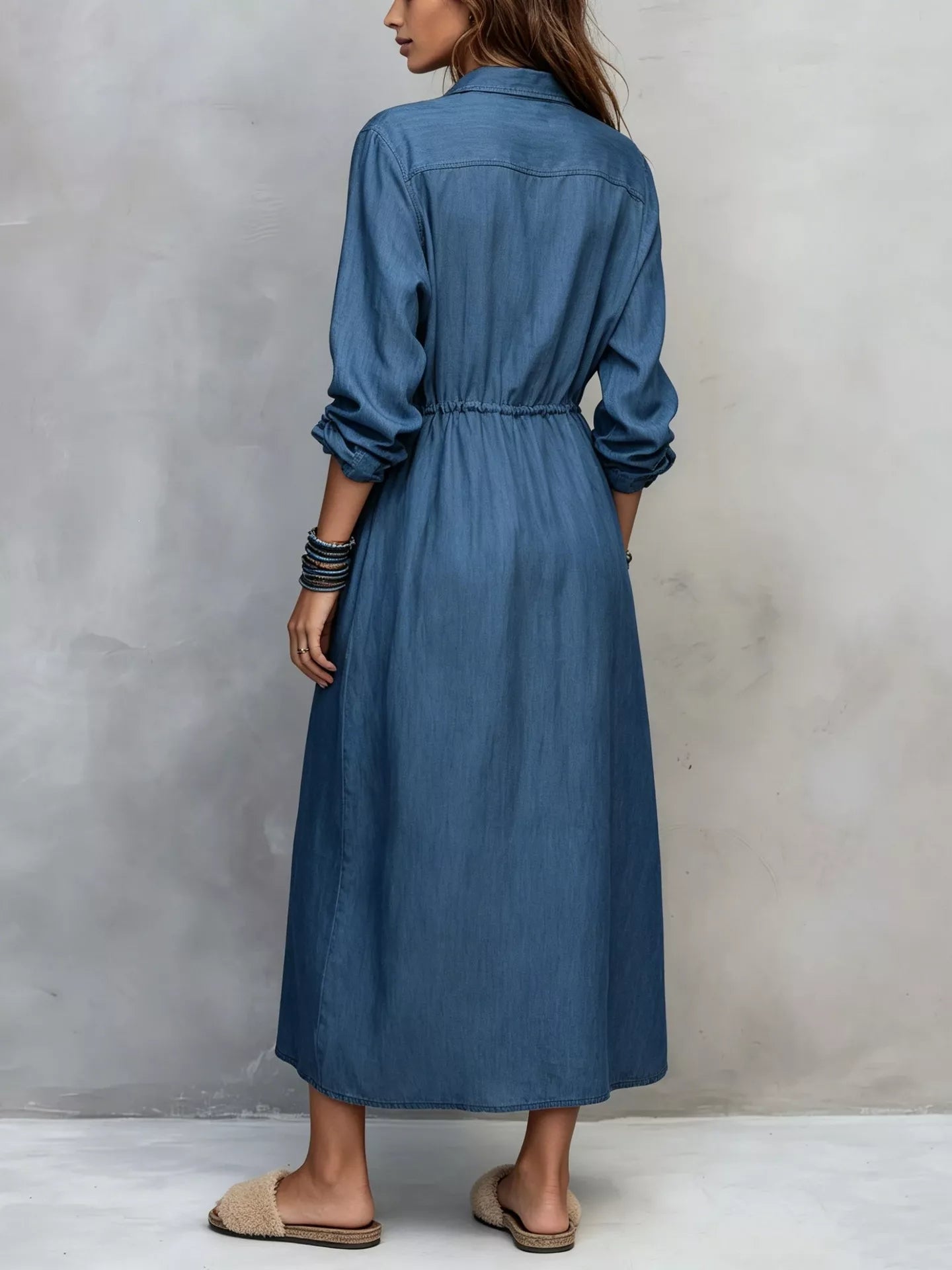 Plus size blue button-front shirt dress with long sleeves, drawstring waist, pockets, and side slit