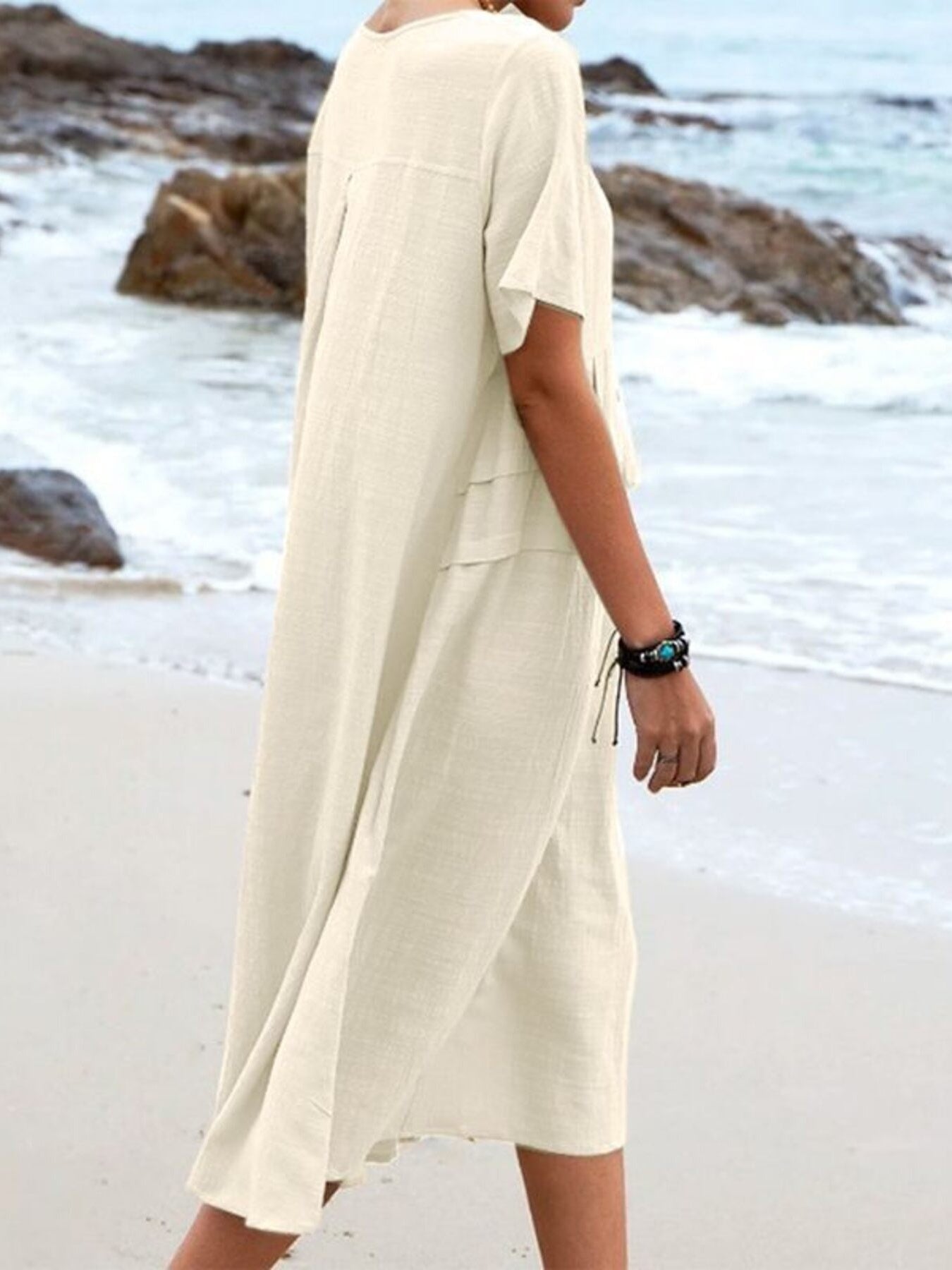 Plus size loose midi dress with short sleeves and pockets shown in cream and black by the beach