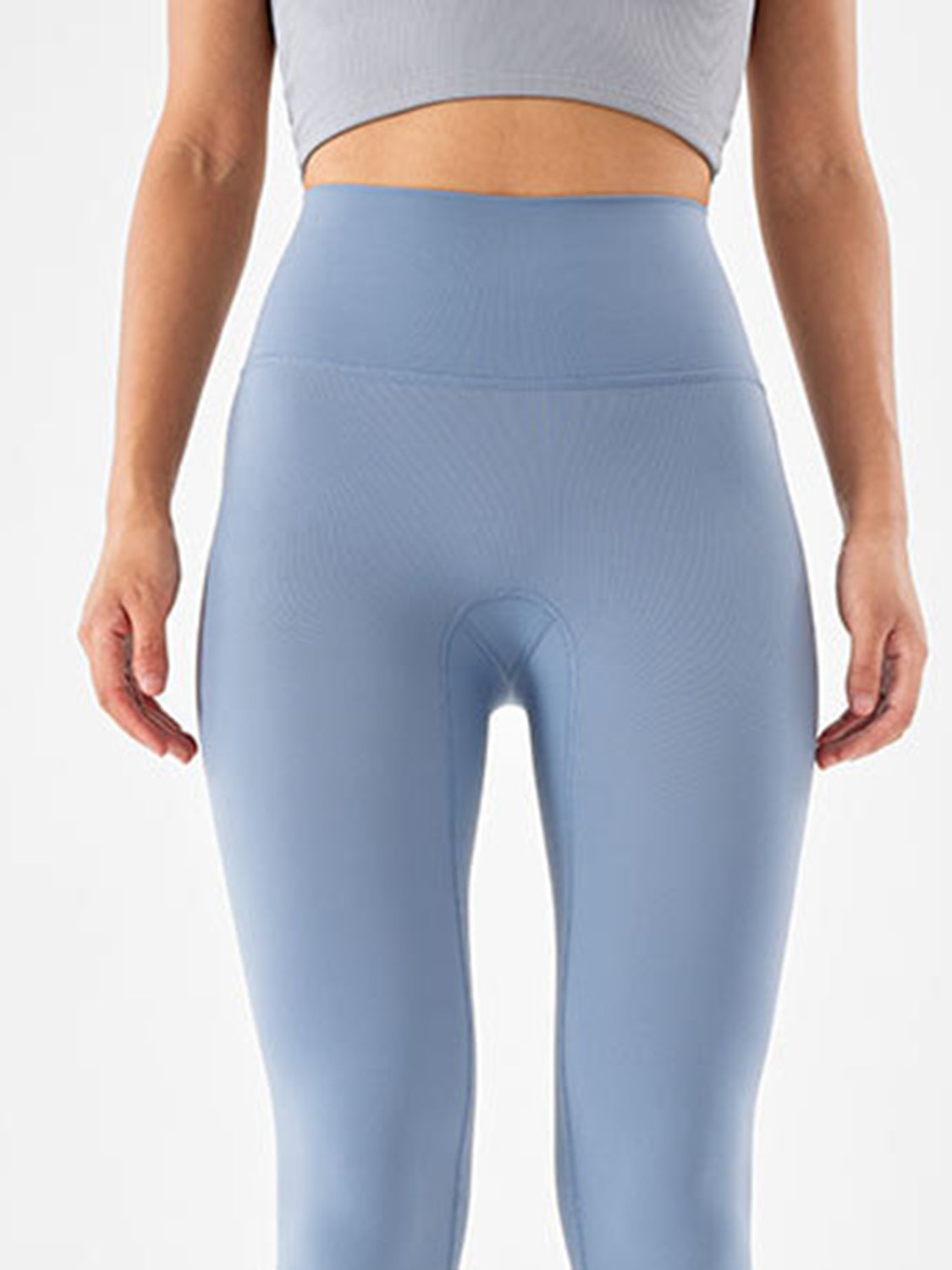 Model stands with hands at her sides wearing light blue sports leggings with a wide high-rise waistband and smooth, fitted full-length silhouette.