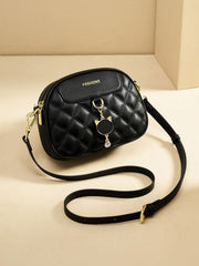 Black mini quilted PU leather crossbody bag with a rounded rectangular silhouette, zip top, flap detail, adjustable strap, and gold-tone hardware.