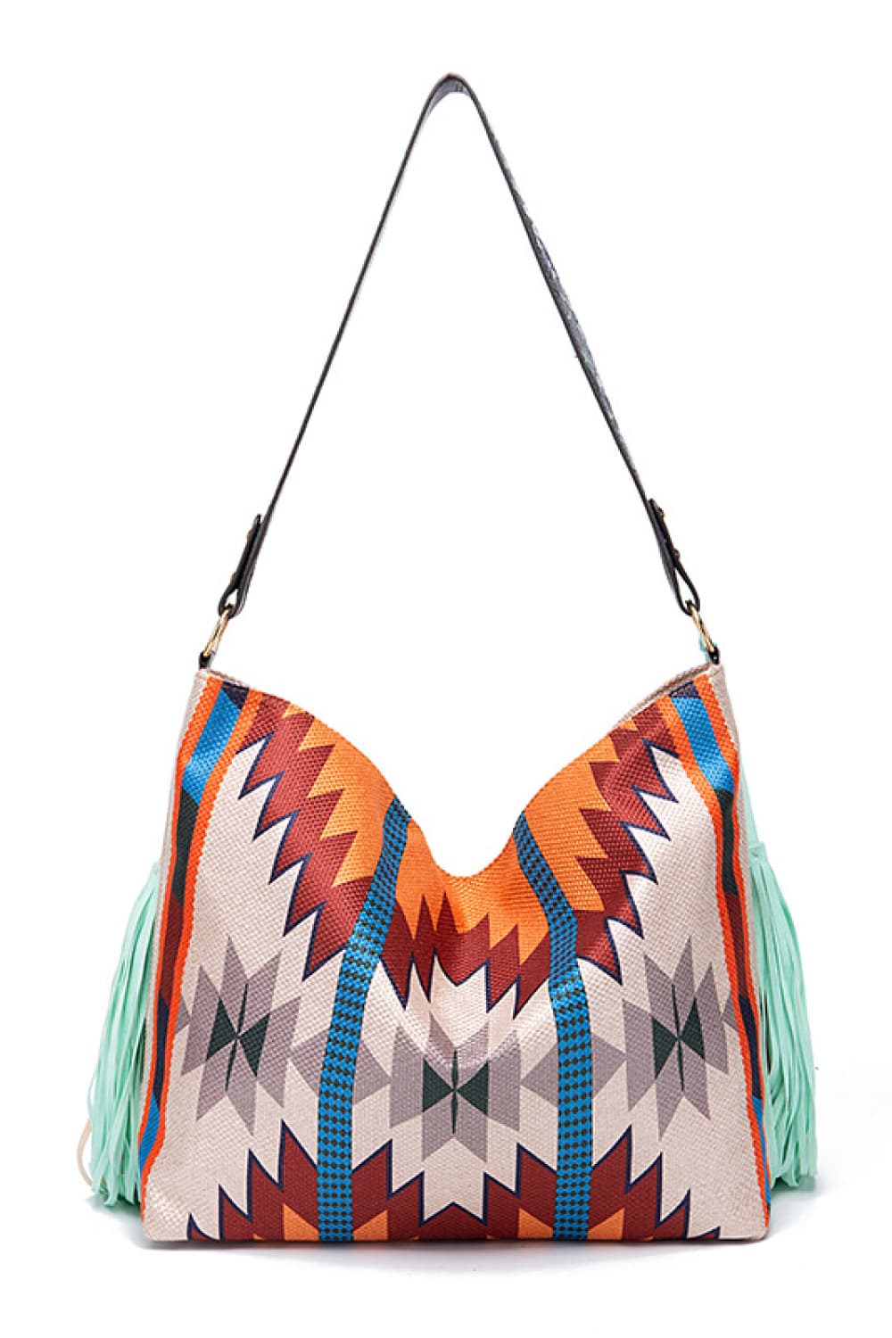 An oversize geometric canvas tote bag features a colorful orange, blue, and cream pattern, long black shoulder strap, gold-tone hardware, and fringed sides.