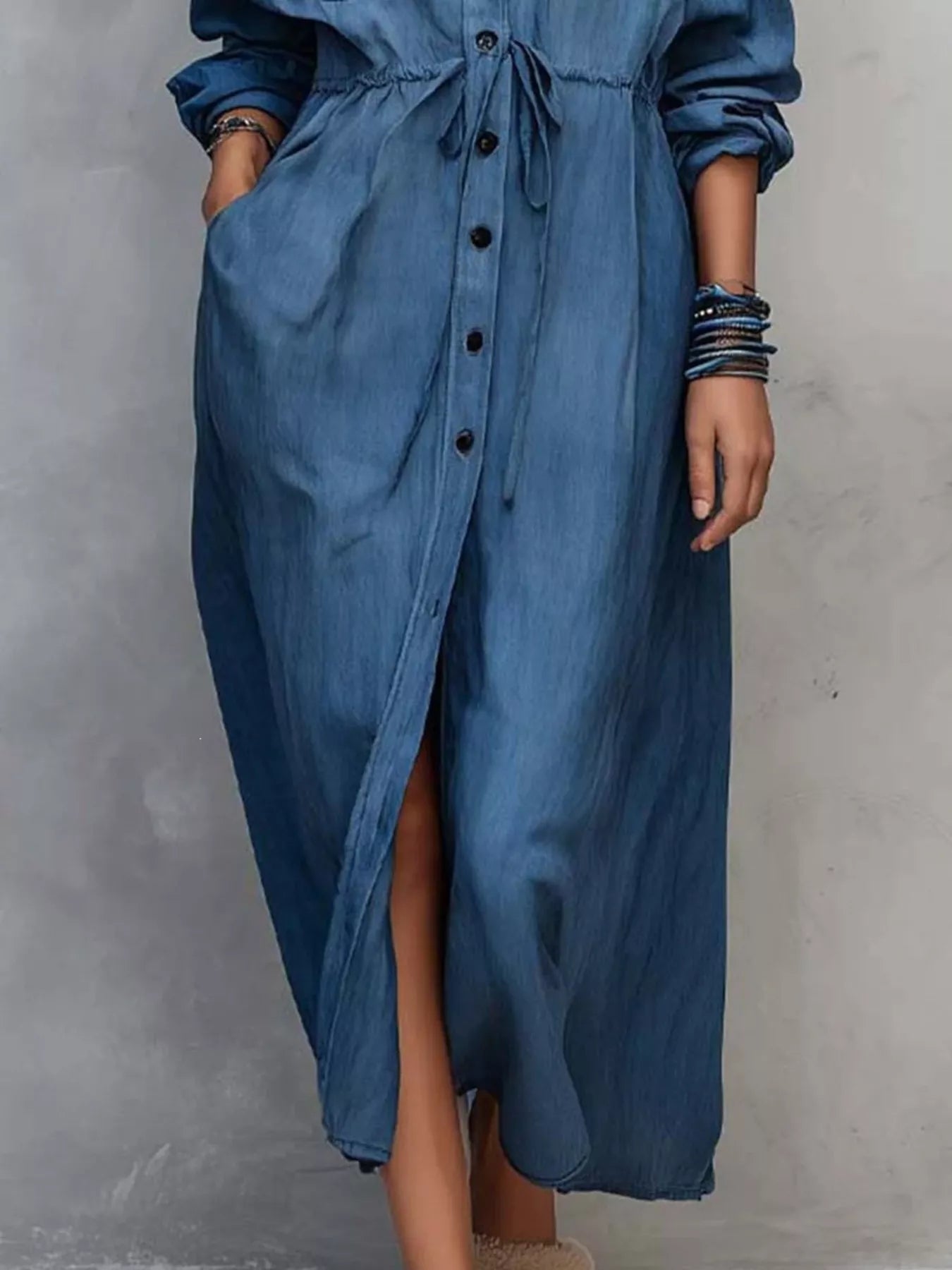 Plus size blue button-front shirt dress with long sleeves, drawstring waist, pockets, and side slit