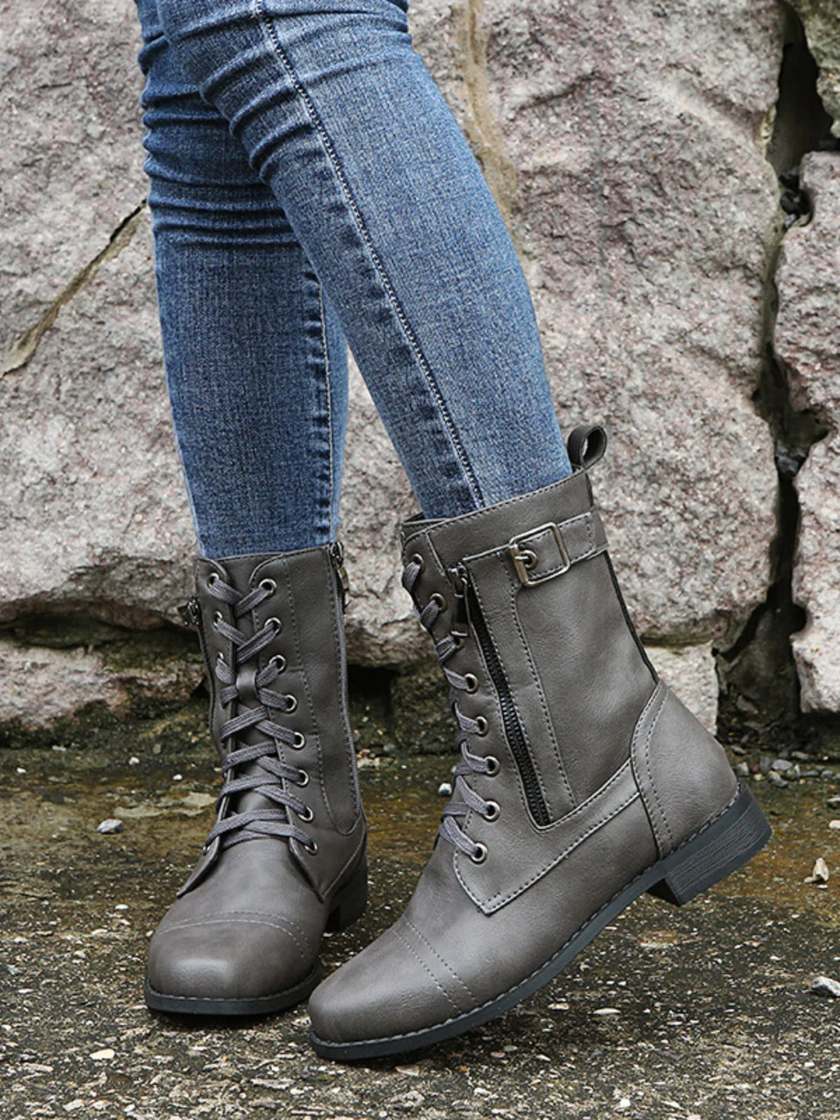Gray PU leather lace-up boots with side zippers, buckle straps, rounded toes, low heels, and rugged rubber soles shown on a model wearing jeans.