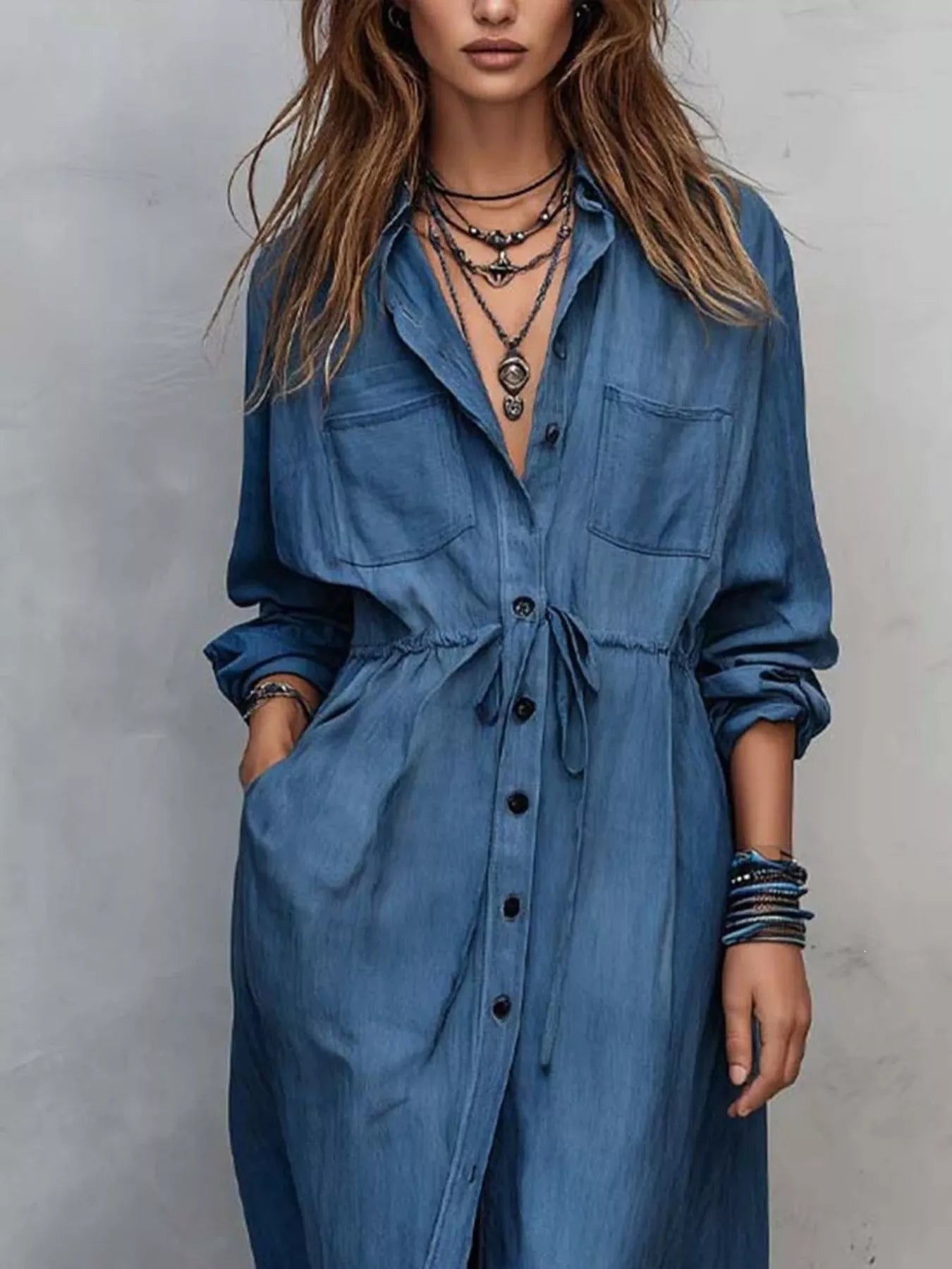 Plus size blue button-front shirt dress with long sleeves, drawstring waist, pockets, and side slit