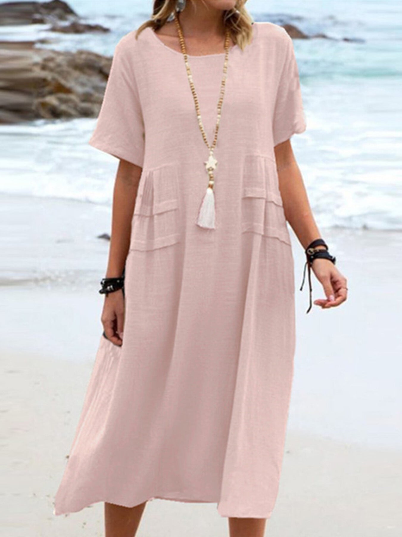 Plus size loose midi dress with short sleeves and pockets shown in cream and black by the beach