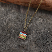 Multicolor alloy books pendant necklace with a delicate gold-tone chain and stacked book-shaped pendant in red, blue, green, orange, and brown.
