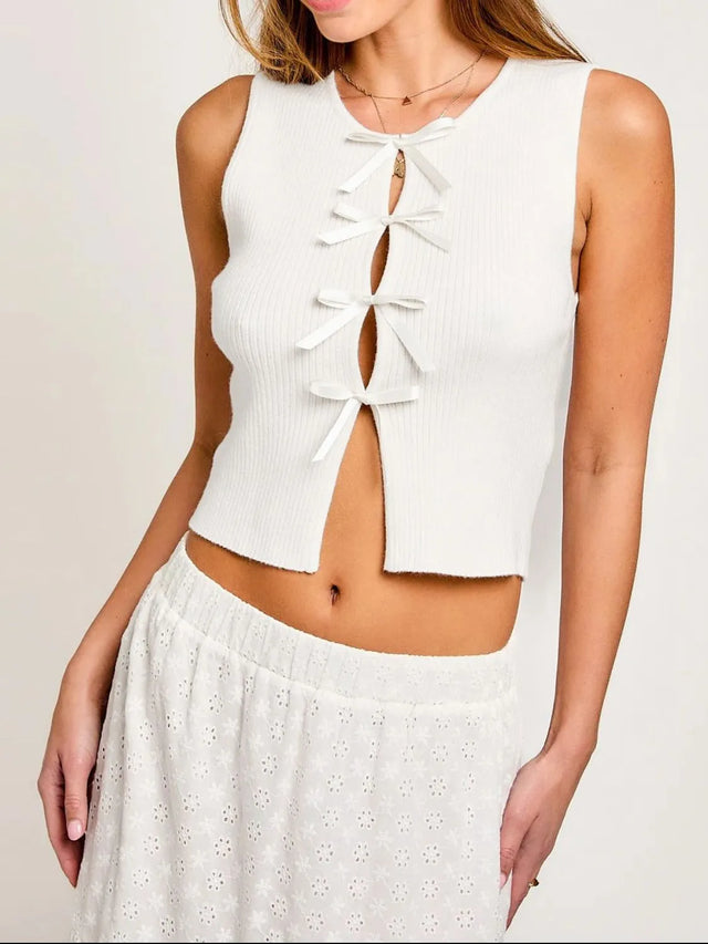 Cropped round neck tank top with bow detail.