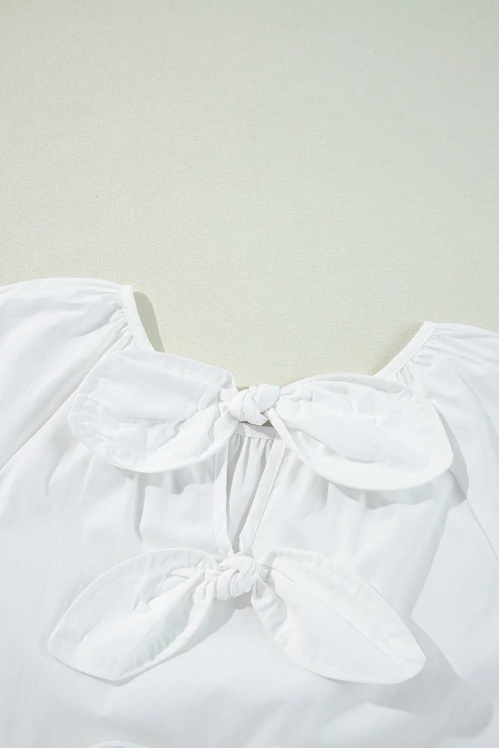 Bow round neck three-quarter sleeve blouse.