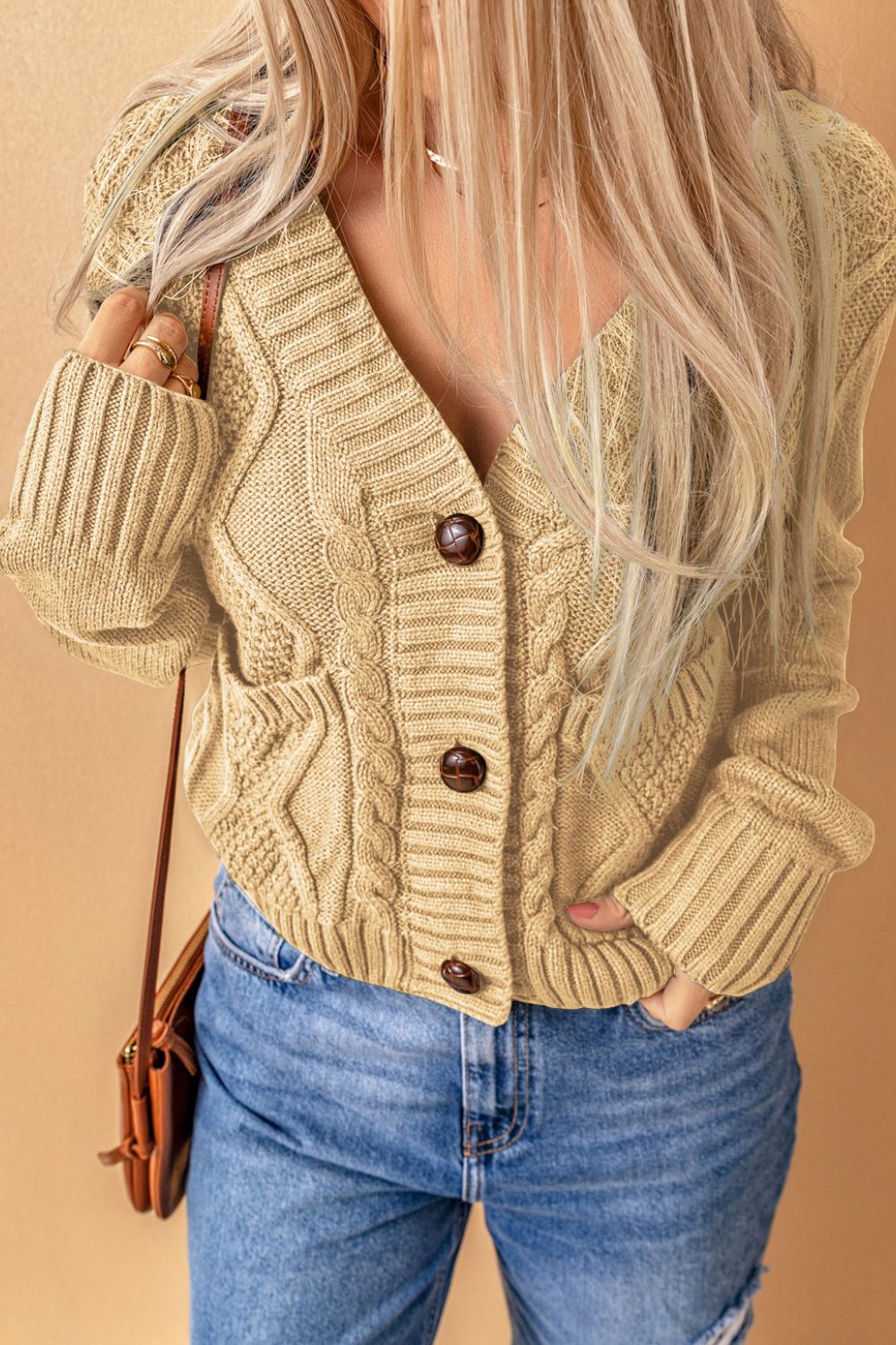 Cable-knit button down V-neck cardigan with pockets.