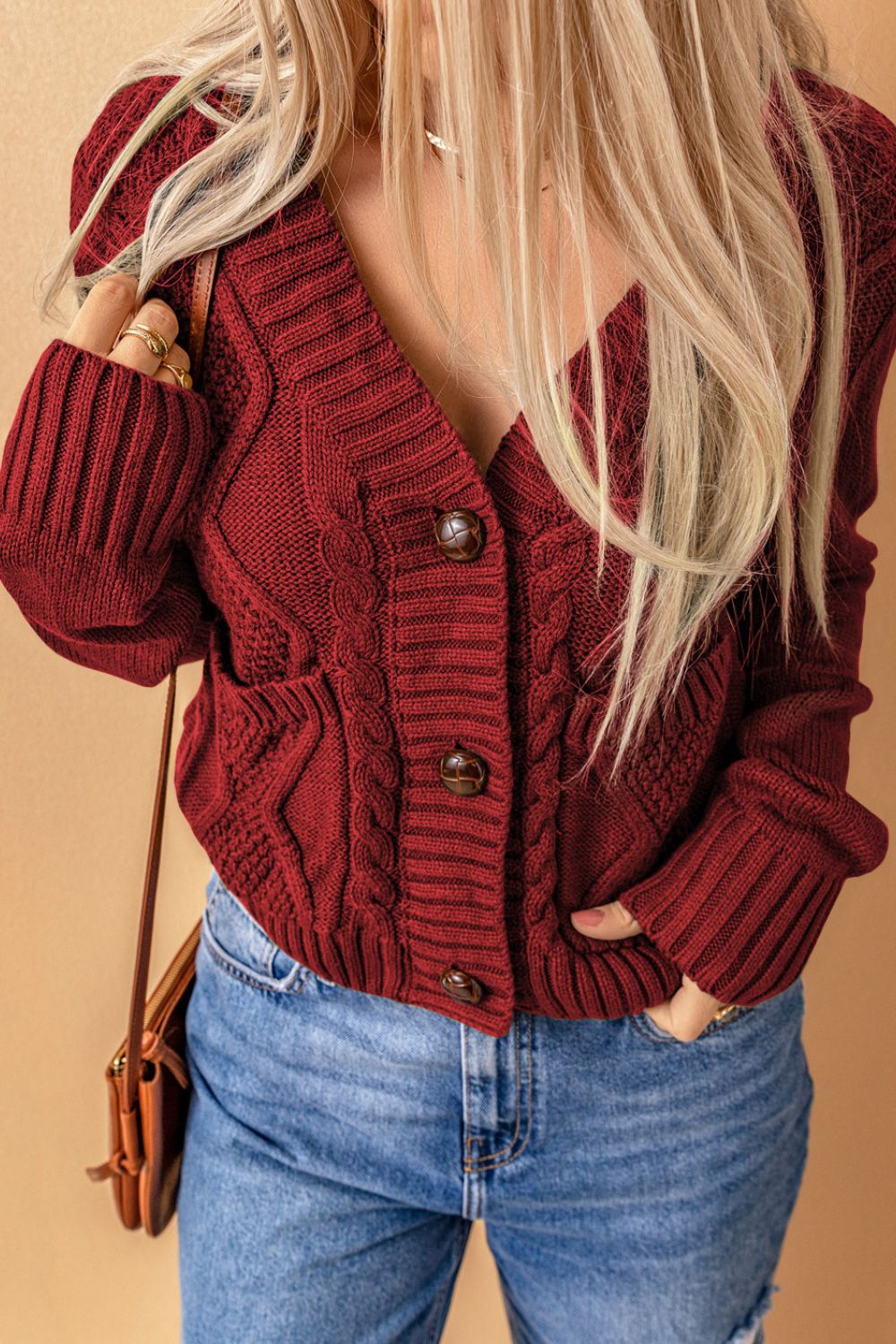 Cable-knit button down V-neck cardigan with pockets.