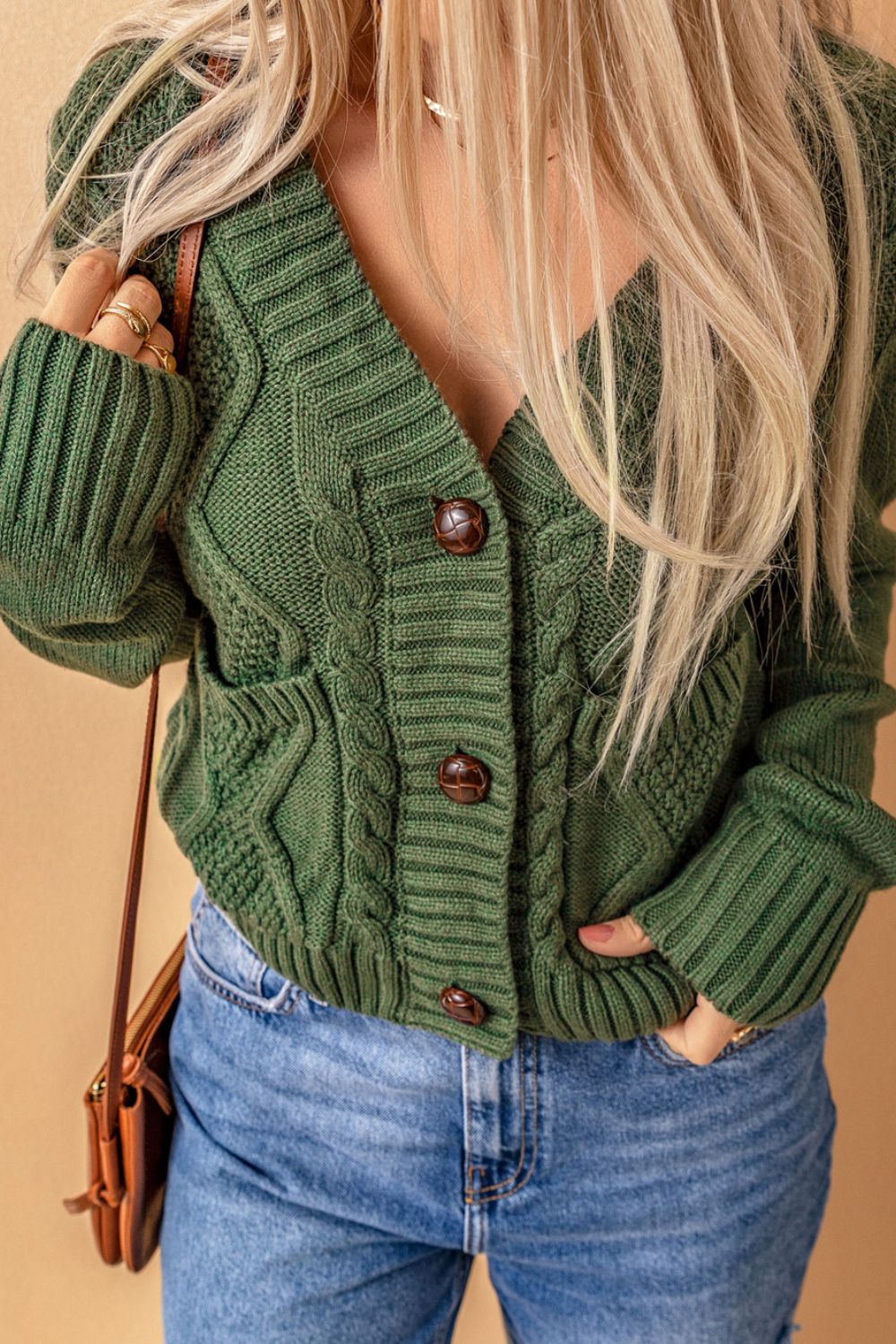 Cable-knit button down V-neck cardigan with pockets.