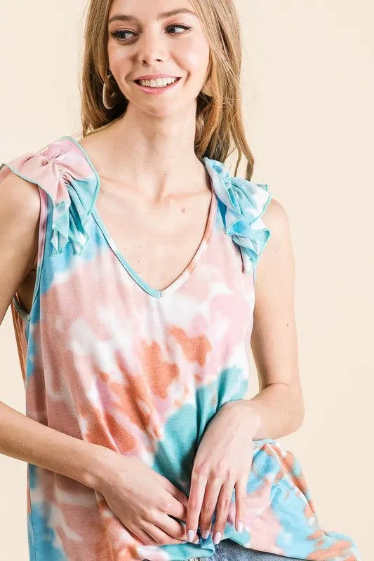Circular tie dye knit V-neck top with ruffle details.