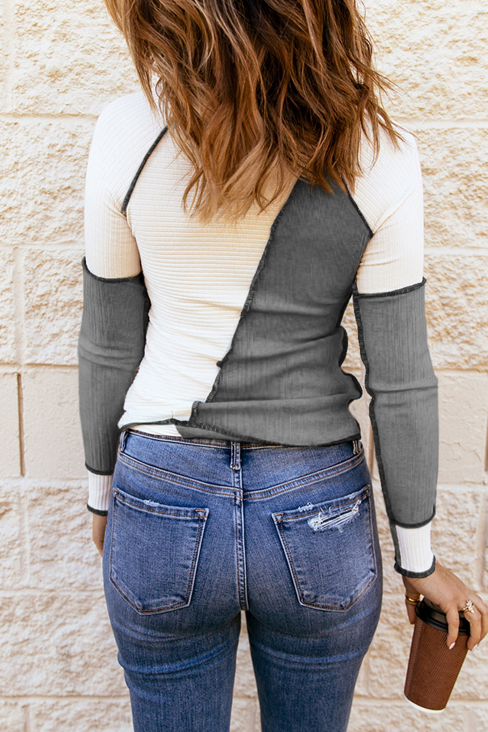 Color block exposed seam knit top with ribbed design.