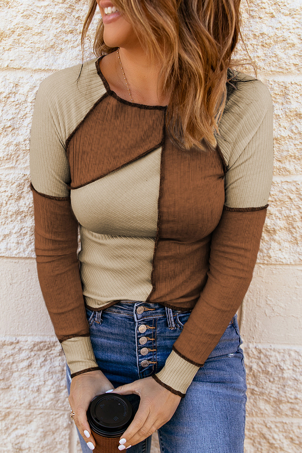Color block exposed seam knit top with ribbed design.