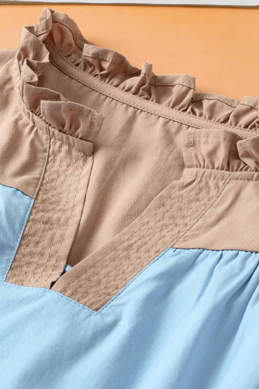 Color block notched ruffled cap sleeve blouse.