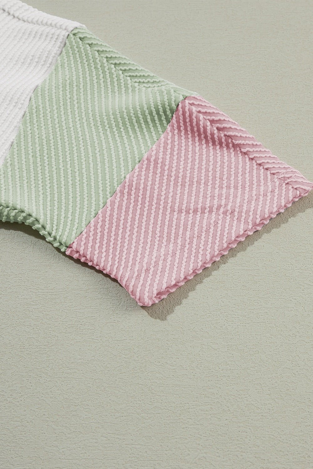 Color block ribbed knit three-quarter sleeve top.