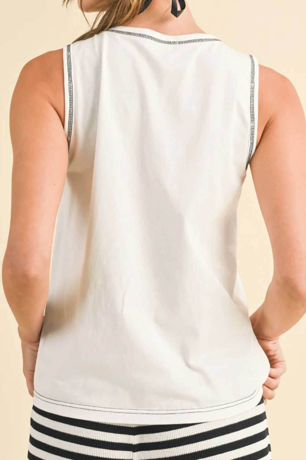 Round neck sleeveless top with contrast bow detail.
