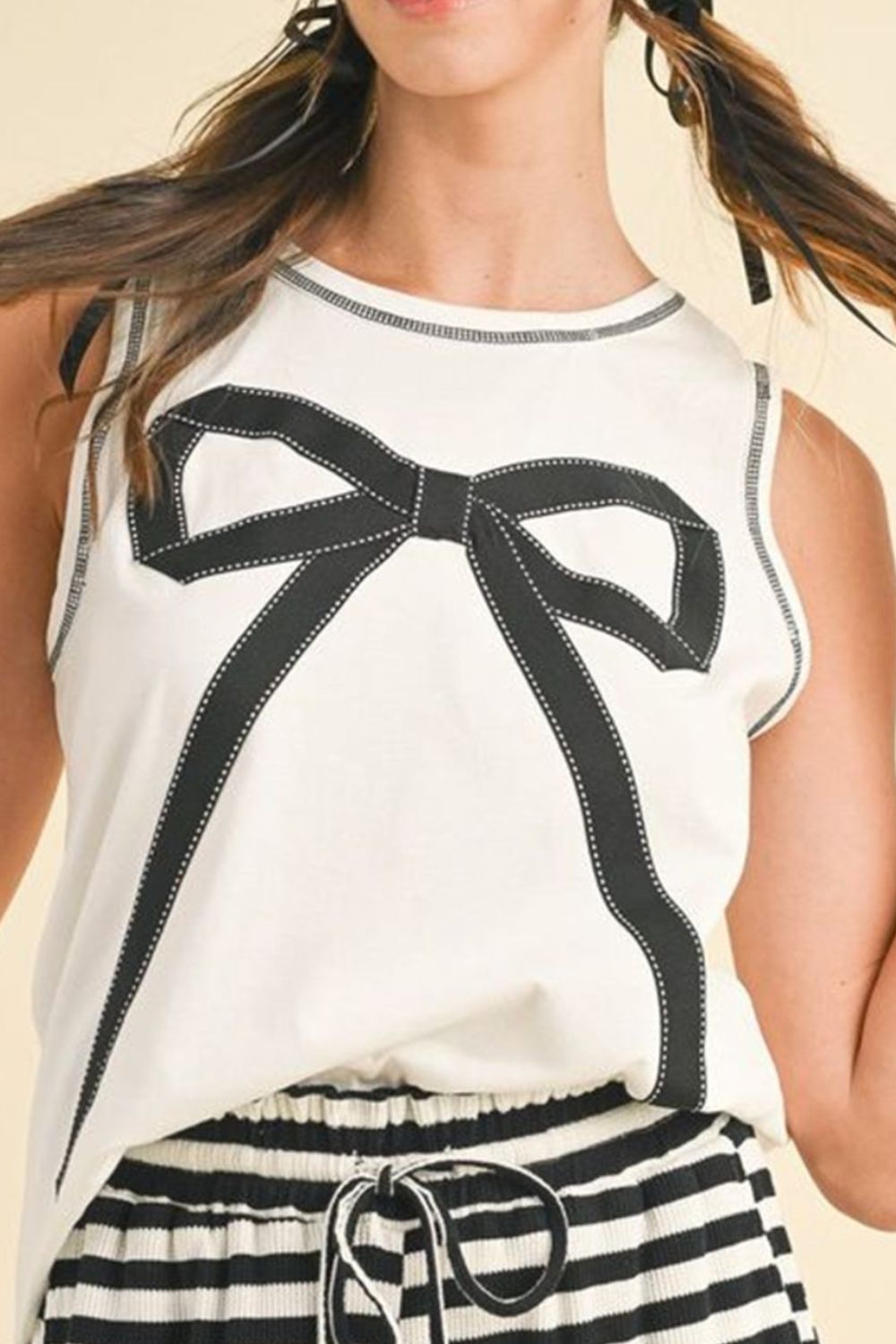 Round neck sleeveless top with contrast bow detail.