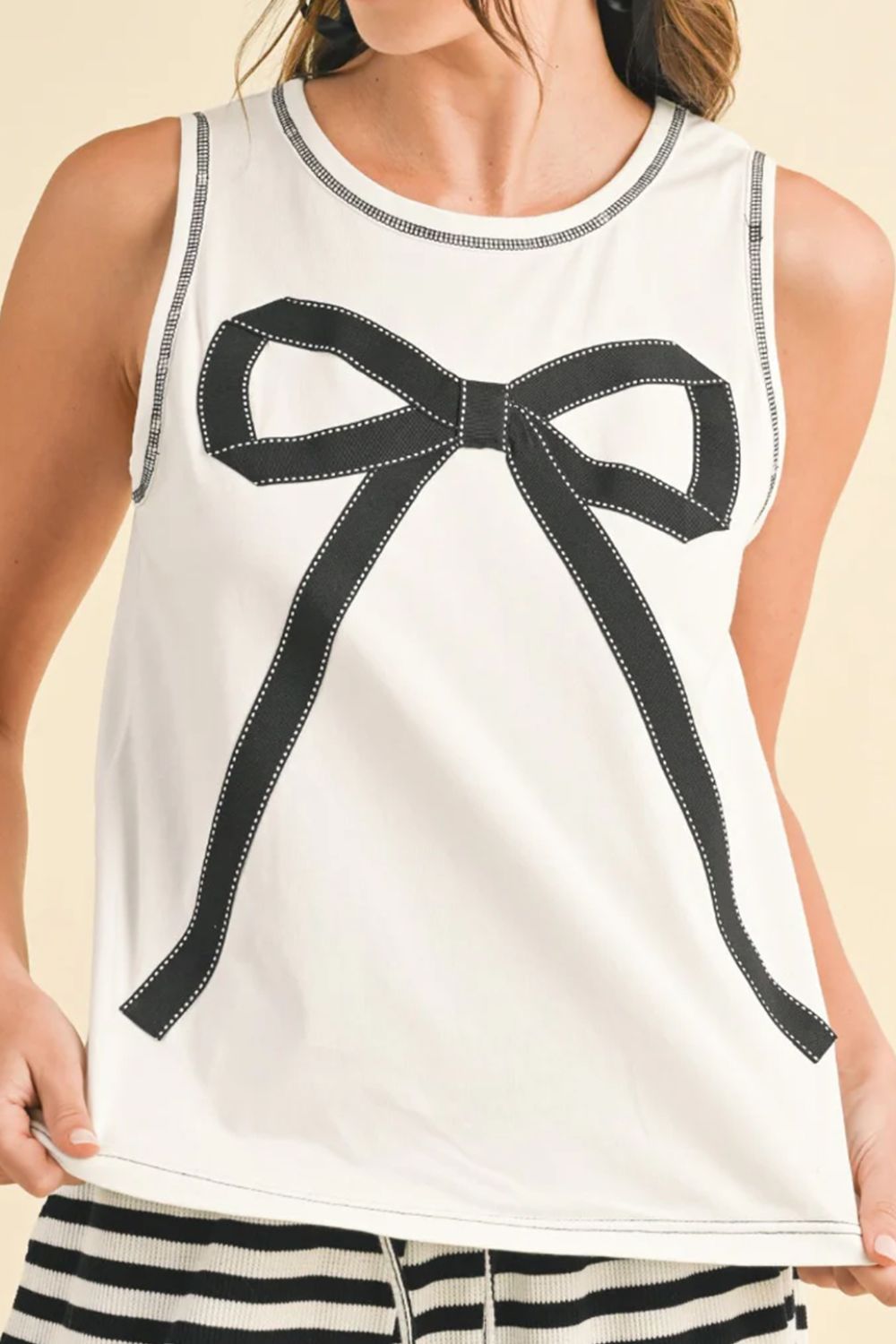 Round neck sleeveless top with contrast bow detail.