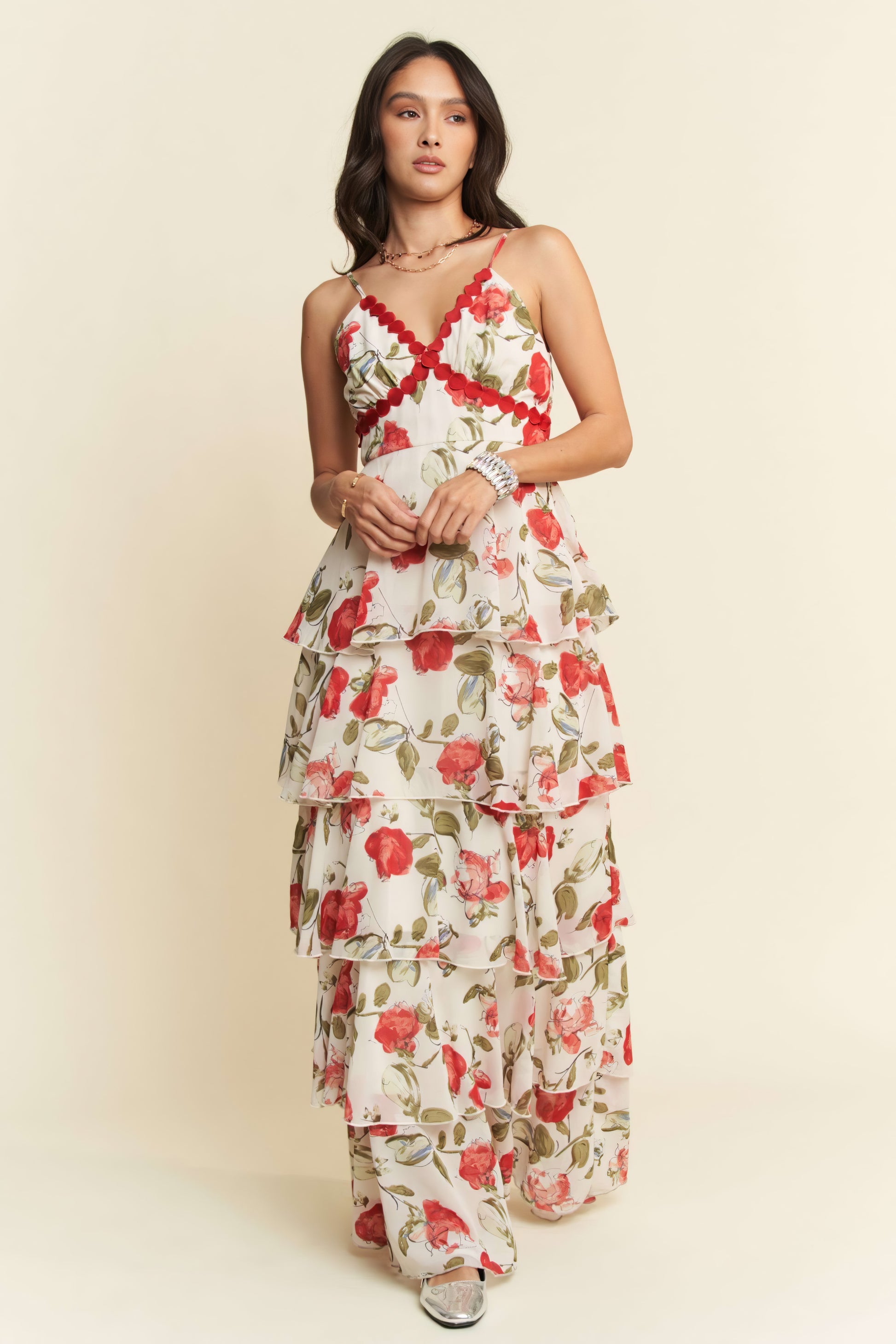 Woman wearing a floral dress with red and green patterns on a beige background