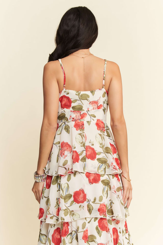 Woman wearing a floral dress with red flowers on a beige background