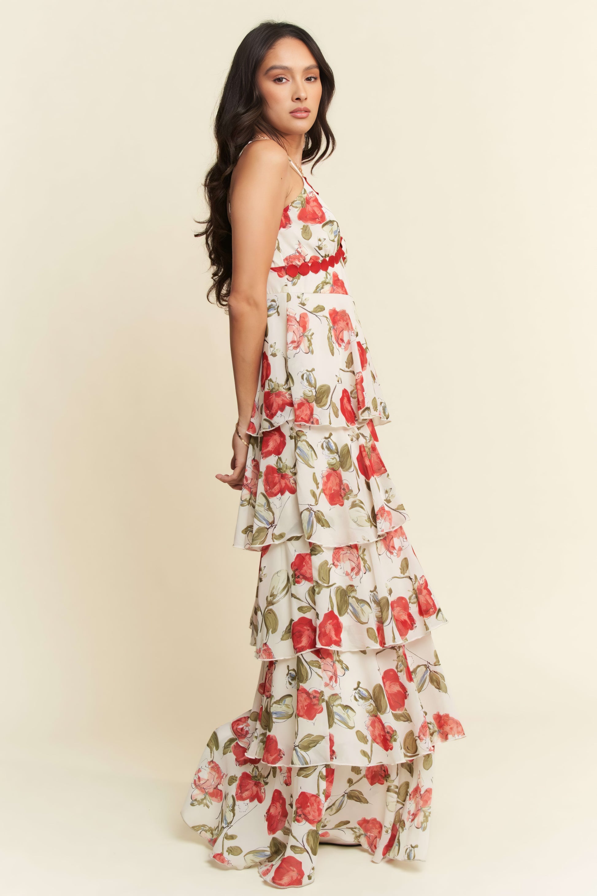 Woman wearing a floral dress with red and green flowers on a beige background