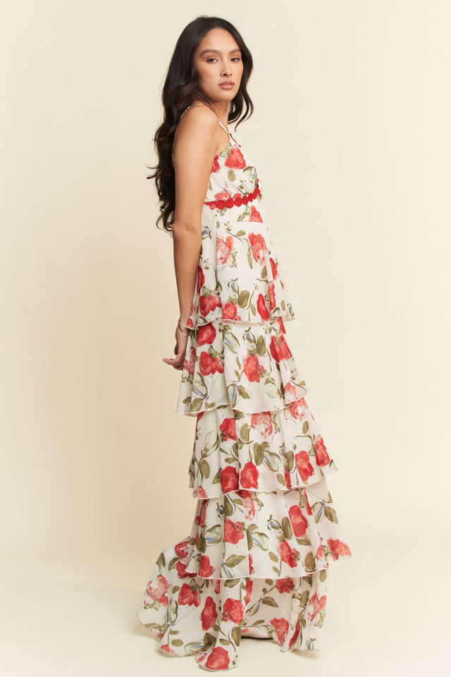 Woman wearing a floral dress with red and green flowers on a beige background