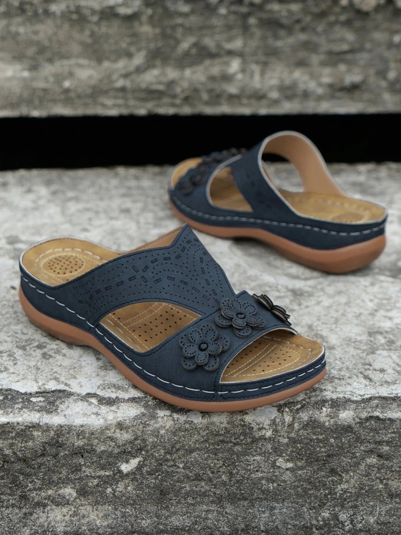 Open-toe flat sandals with cutout flower design.