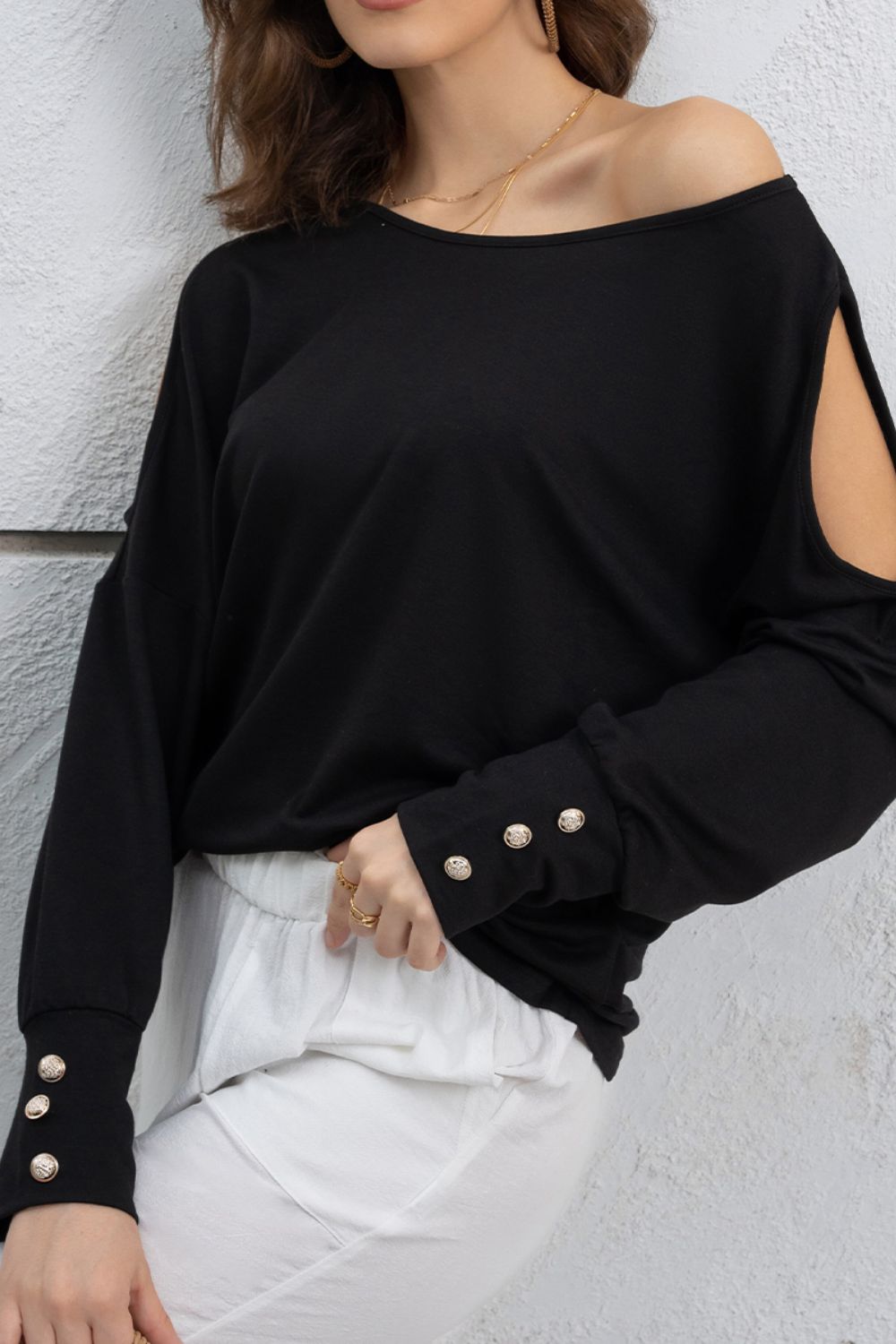 Cutout round neck long sleeve top with decorative buttons.