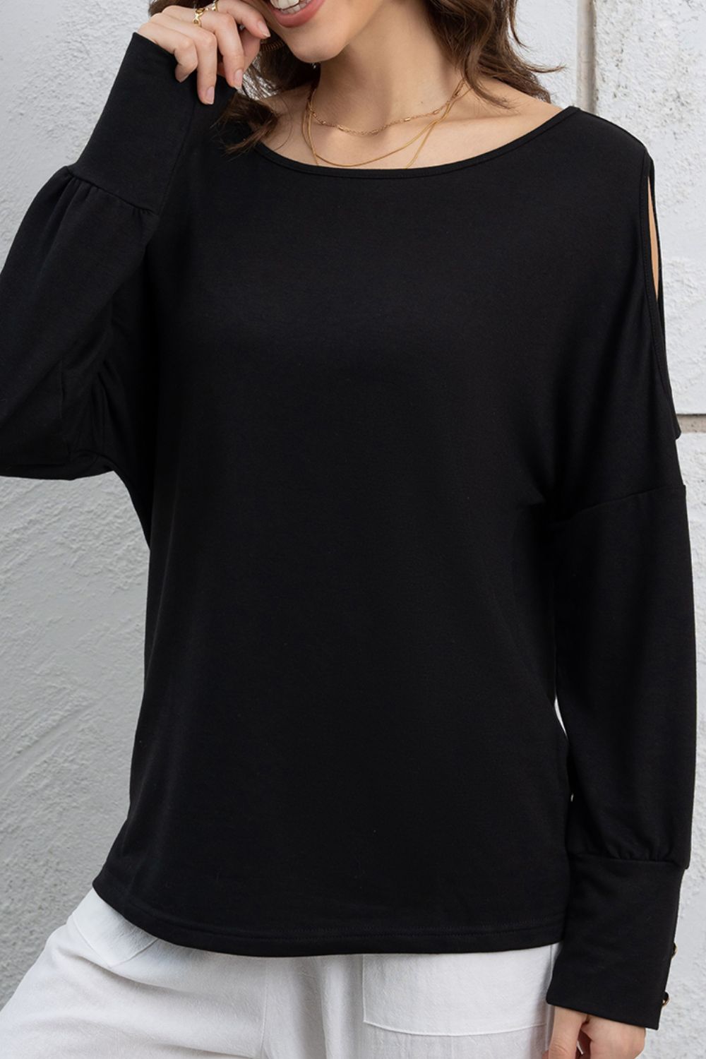 Cutout round neck long sleeve top with decorative buttons.