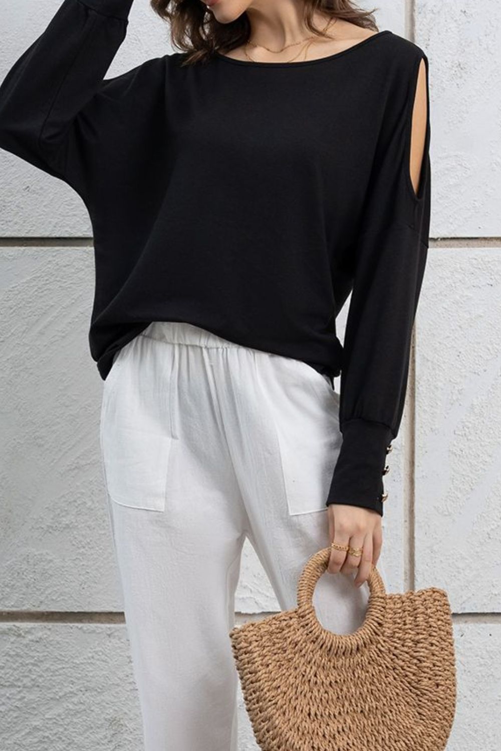 Cutout round neck long sleeve top with decorative buttons.