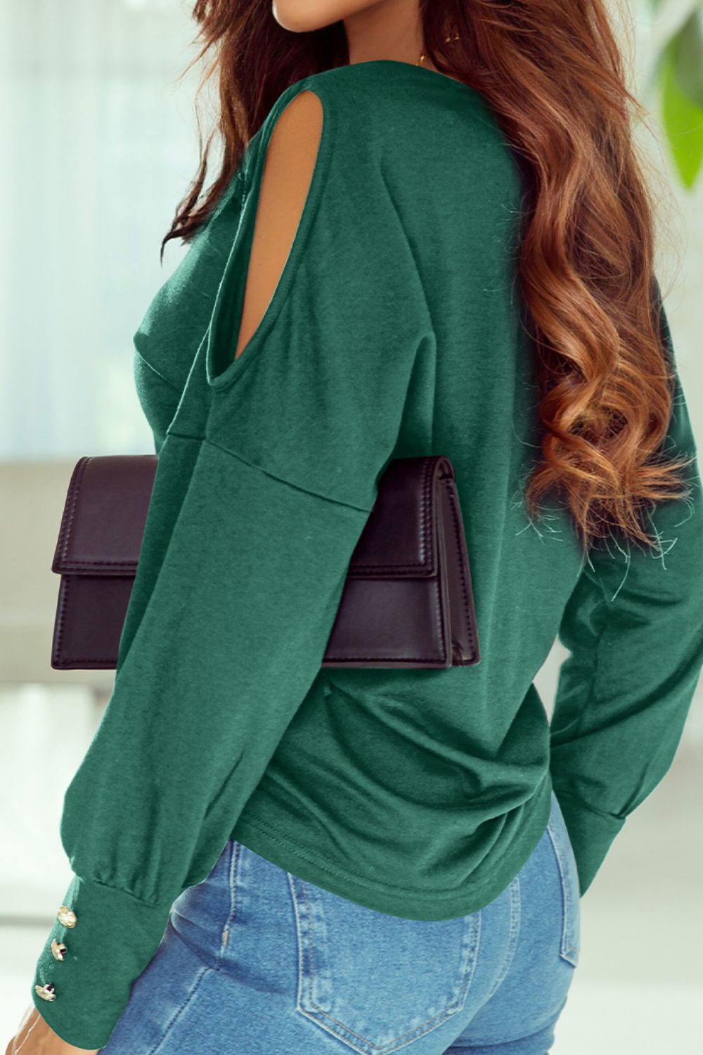 Cutout round neck long sleeve top with decorative buttons.