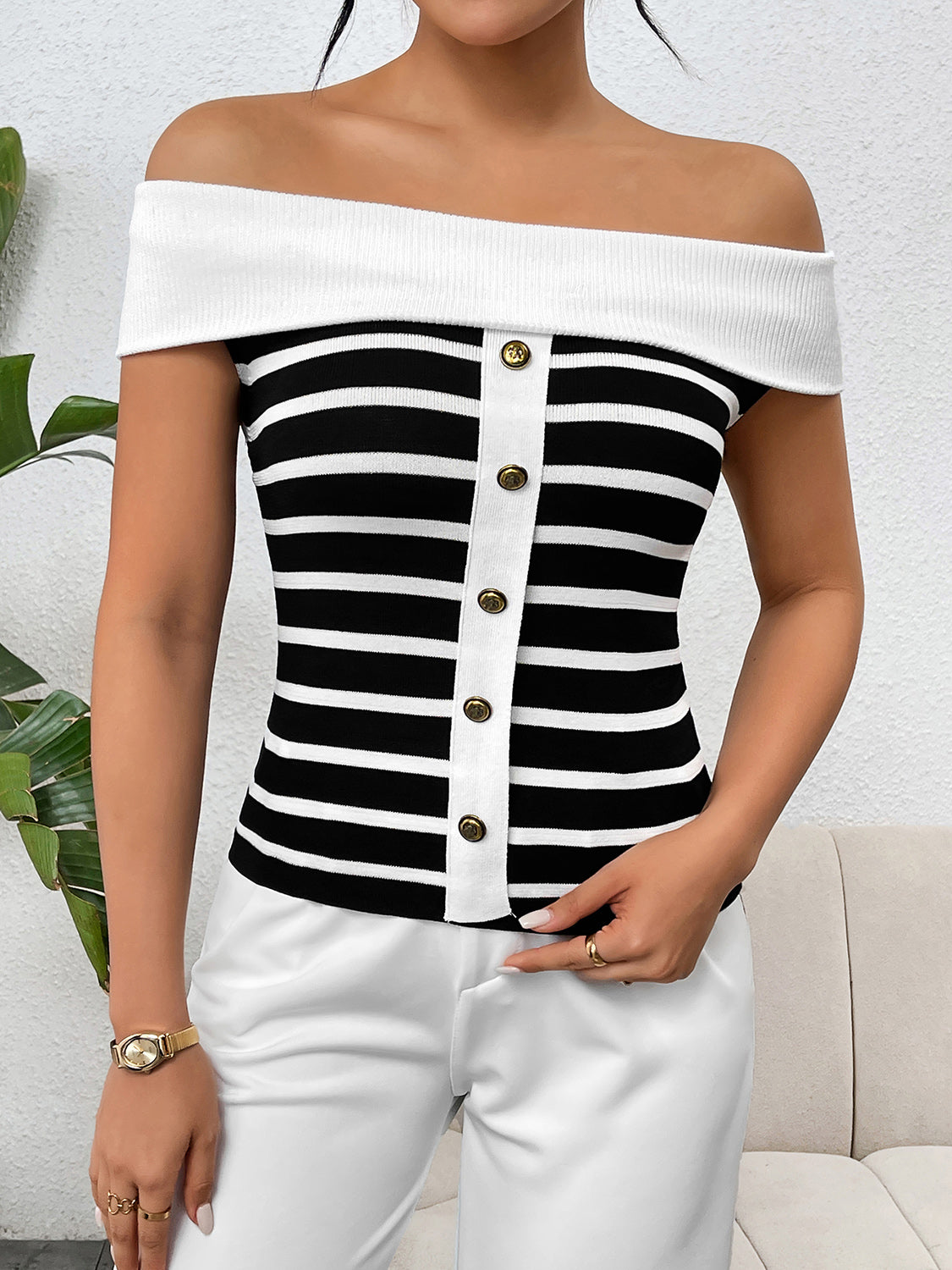 Decorative button striped off-shoulder knit top.